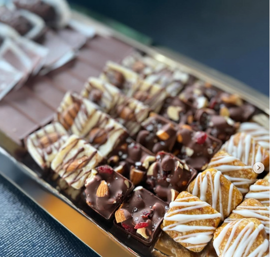 Assorted chocolate pieces in a box on a blue surface